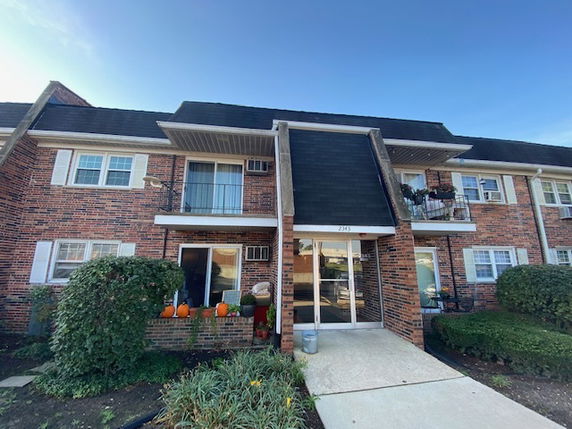 Front view of a two-story brick apartment building with balconies.