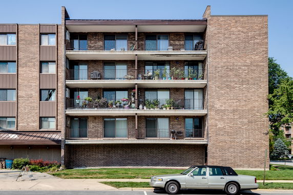 Front view of a multi-story apartment building with balconies.