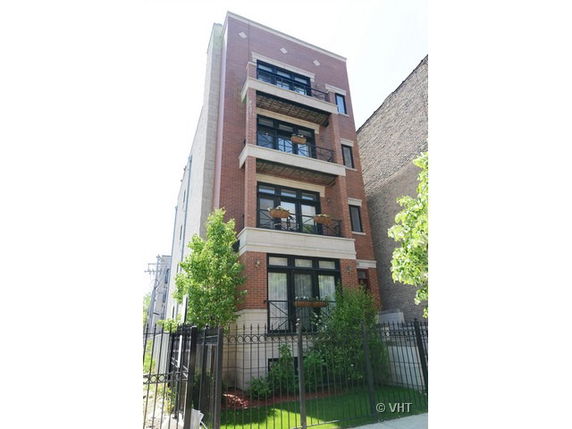 Front view of a multi-story brick building with balconies.