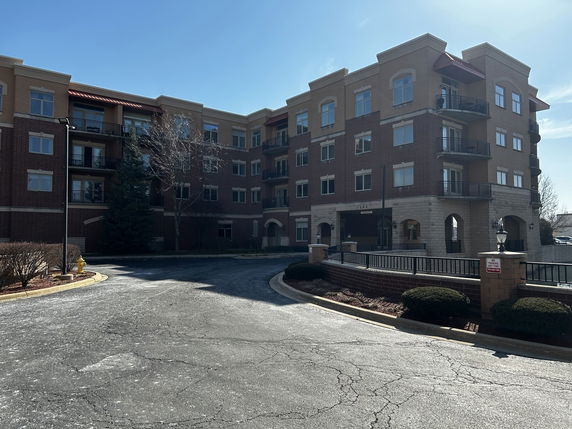 Front view of a multi-story apartment building with balconies.