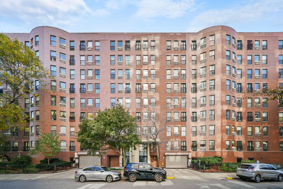 Front view of a multi-story apartment building with brick facade.