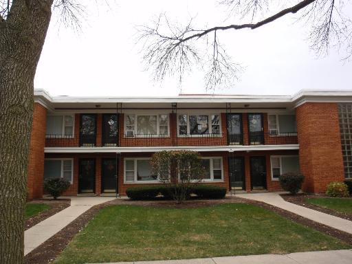 Front view of a two-story brick building with multiple entrances.