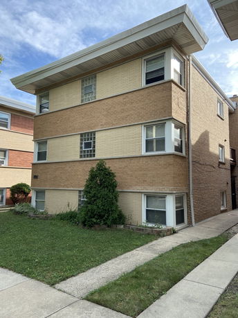 Front view of a three-story brick apartment building.