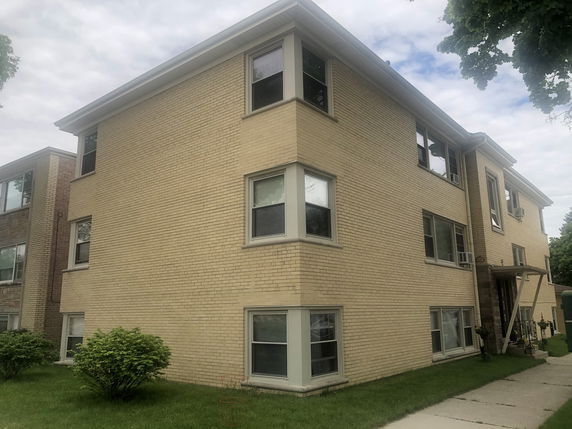 Front view of a three-story apartment building with brick exterior.
