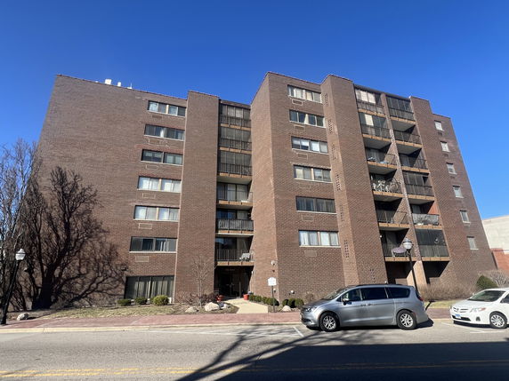 Front view of a multi-story apartment building with balconies.