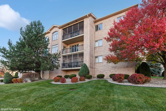 Front view of a multi-story brick residential building with balconies.