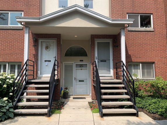 Front view of a brick building with two entry doors and staircases.