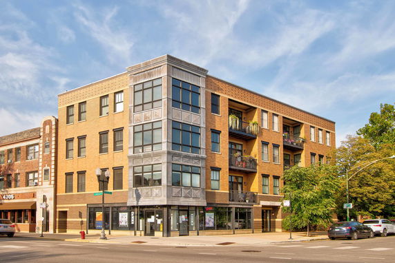 Front view of a multi-story brick building with balconies.