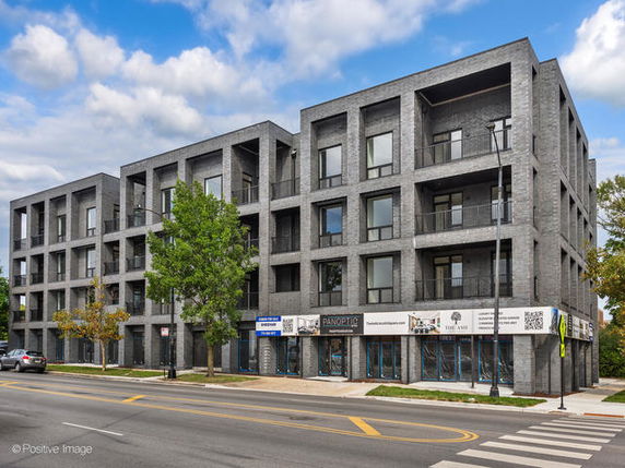 Front view of a modern multi-story building with rectangular design features and large windows.