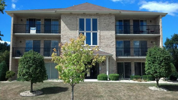 Front view of a three-story apartment building with balconies.
