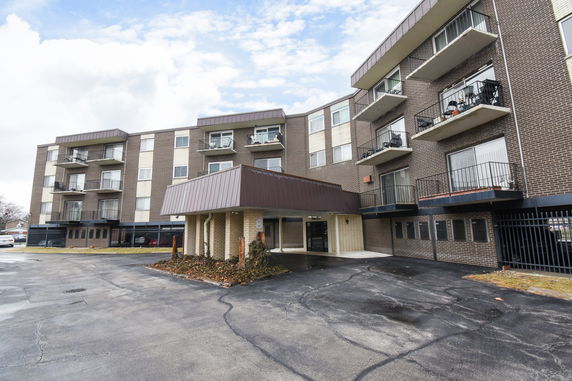 Front view of a multi-story apartment building with balconies.
