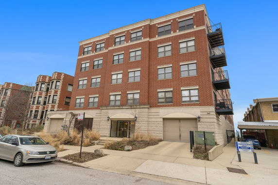 Front view of a multi-story brick building with balconies.