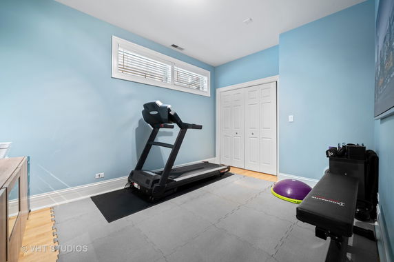 Indoor gym area with treadmill and workout equipment.