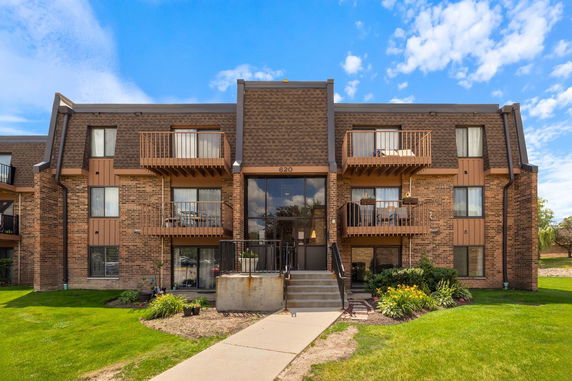 Front view of a multi-story apartment building with balconies.
