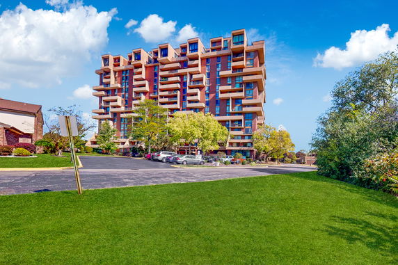 Front view of a multi-story residential building with modern design elements and balconies.