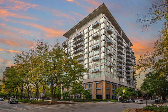 Front view of a modern multi-story residential building with balconies.