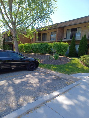 Front view of a two-story residential building with balconies and brick facade.