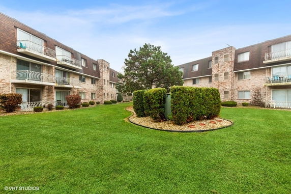 Front view of a multi-story apartment building with balconies.