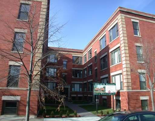 Front view of a multi-story brick building with multiple windows.