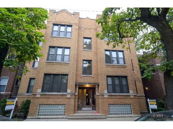 Front view of a multi-story brick building with multiple windows.