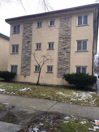 Front view of a three-story building with brick and stone facade.