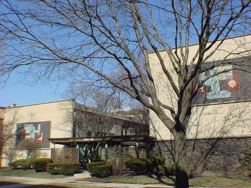 Front view of a building with decorative wall art and a flat roof.