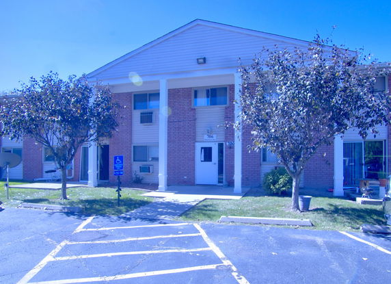 Front view of a two-story building with brick facade and white columns.