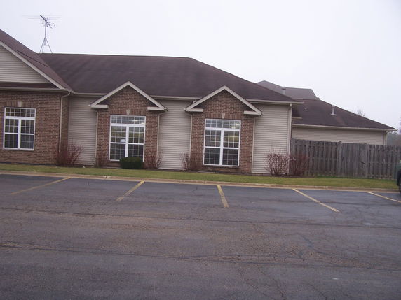 Front view of a building with large windows and an antenna on the roof.
