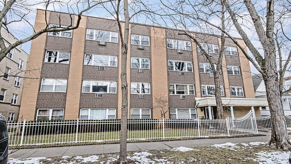 Front view of a four-story brick apartment building.