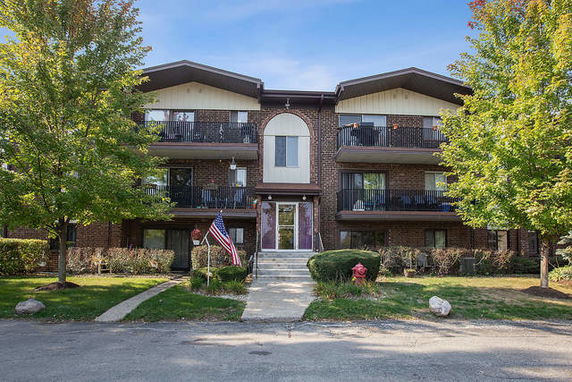 Front view of a three-story residential building with balconies.