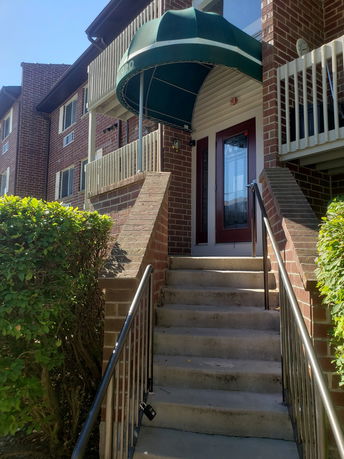 Front view of a building with a green awning over the entrance.