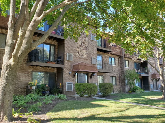 Front view of a multi-story apartment building with balconies.