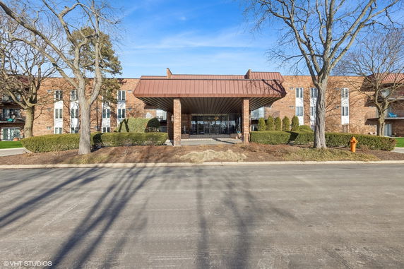 Front view of a large brick building with a covered entrance.