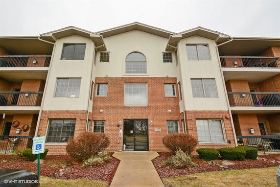 Front view of a multi-story residential building with balconies.