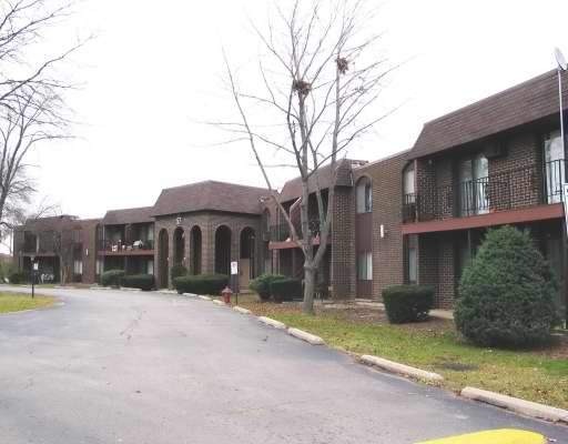 Front view of a brick apartment building with arched entrances.