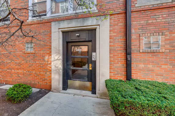 Entrance view of a brick building with a black door.