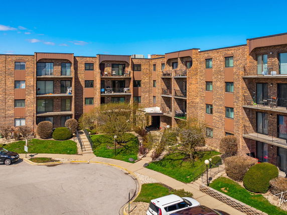 Front view of a multi-story apartment building with balconies.