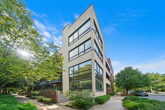 Front view of a modern multi-story building with large windows.