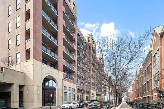 Front view of a multi-story apartment building with balconies.