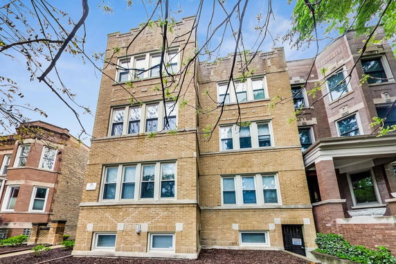 Front view of a multi-story brick building with multiple windows.