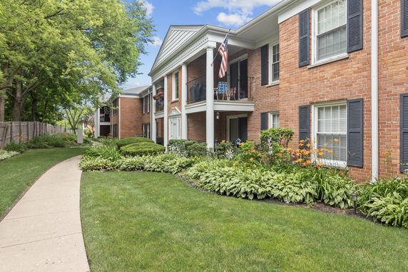Front view of a two-story brick building with balconies and white columns.