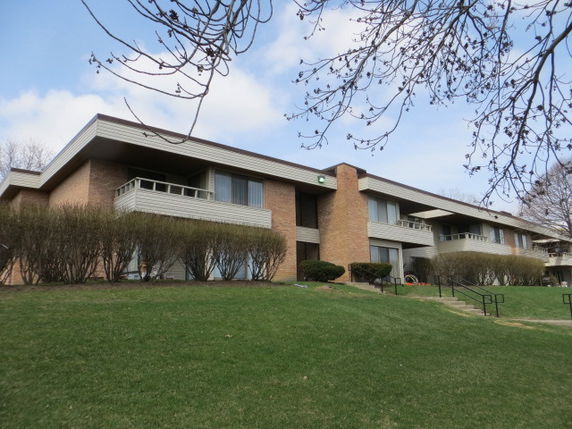 Front view of a two-story apartment building with balconies.