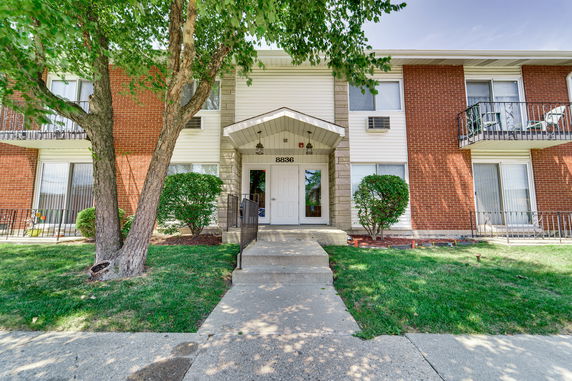 Front view of a two-story residential building with brick and siding exterior.