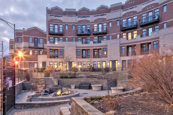 Front view of a multi-story residential building with brick and stone exterior.