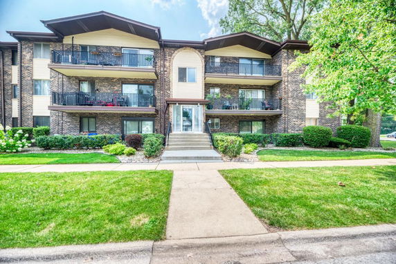 Front view of a three-story apartment building with balconies.