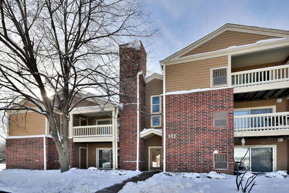 Front view of a multi-story building with balconies and brick facade.