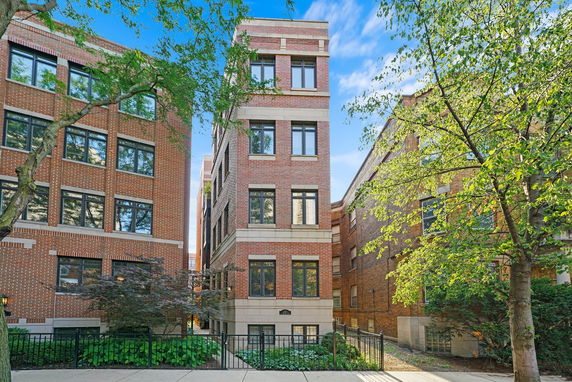 Front view of a multi-story brick building with large windows.