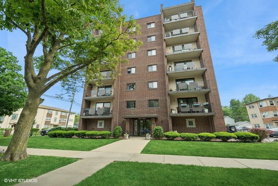 Front view of a multi-story apartment building with balconies.