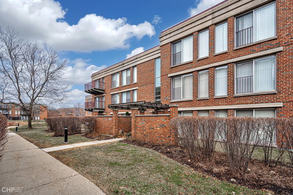 Front view of a multi-story brick building with multiple windows and balconies.