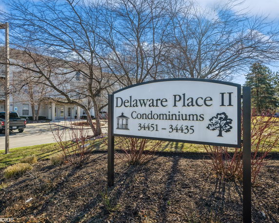 Front view of a condominium building with a sign reading 'Delaware Place II Condominiums'.